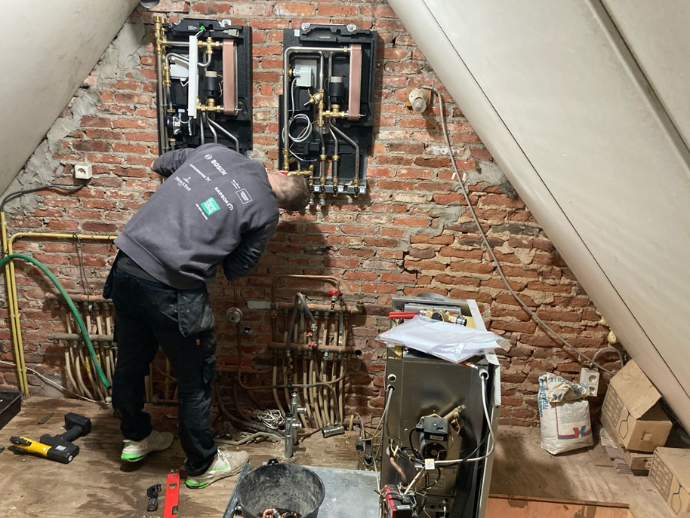 A Heatco technician installs two heat distribution units in a shared utility room, serving two different homes.